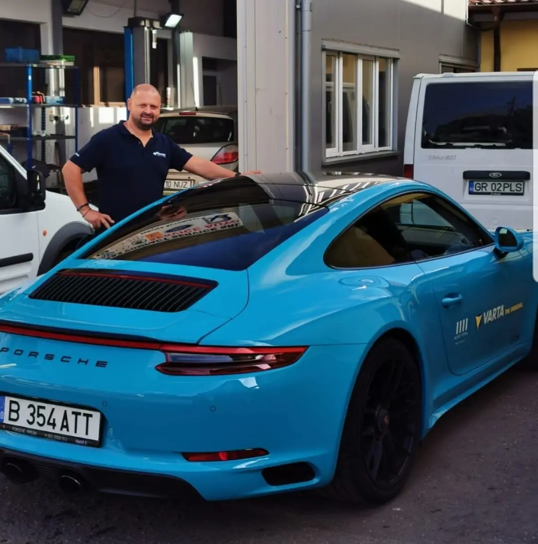 man standing next to a porche